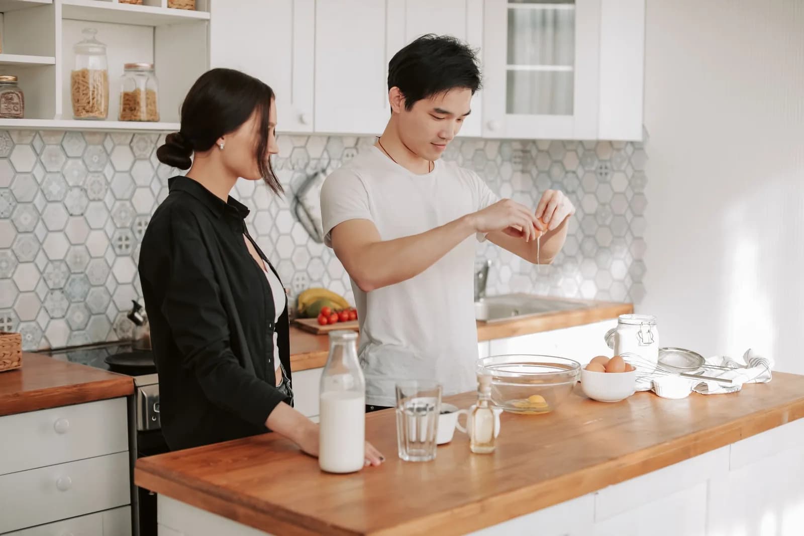 Two people preparing a meal together in a bright kitchen